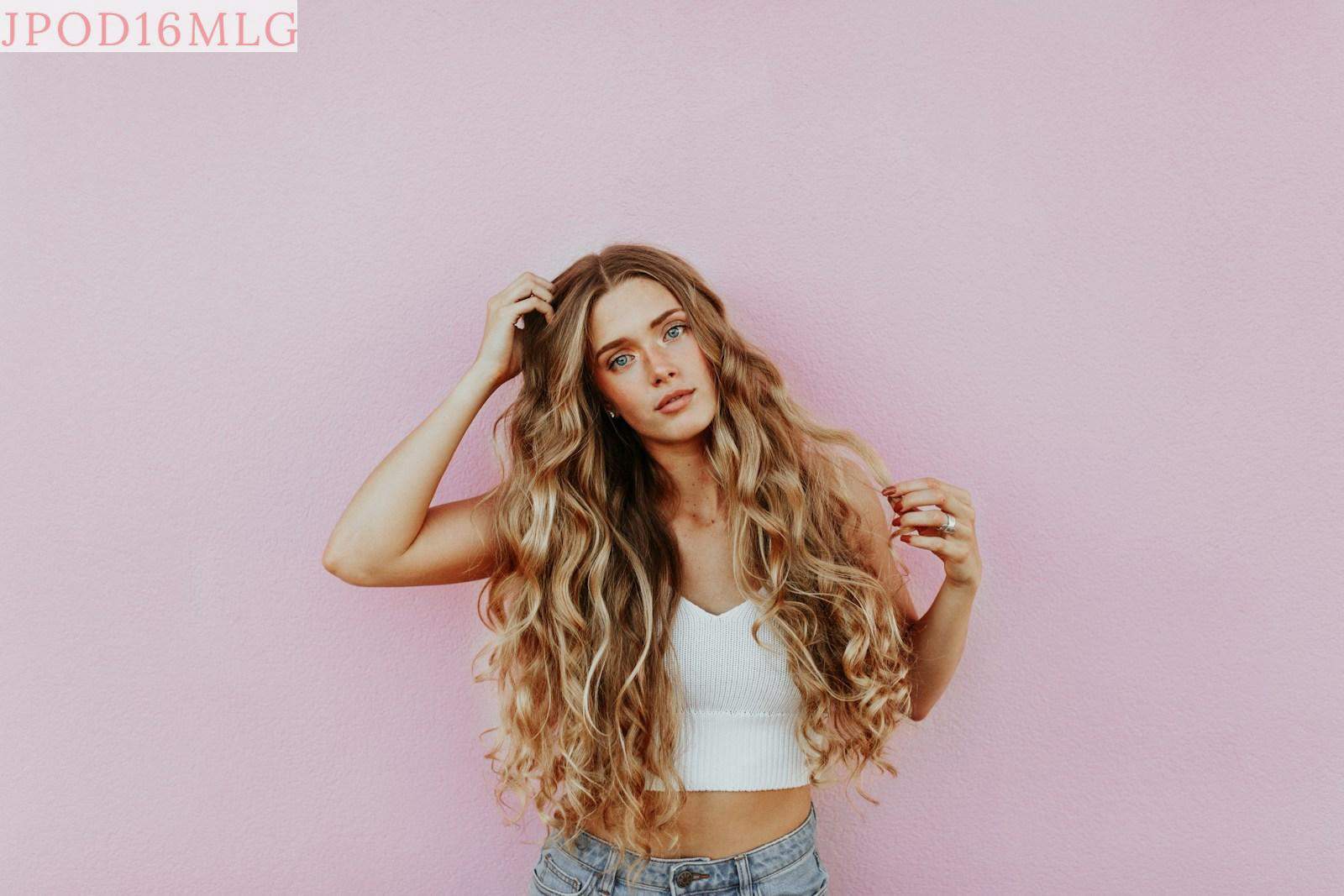 woman standing next to pink wall while scratching her head