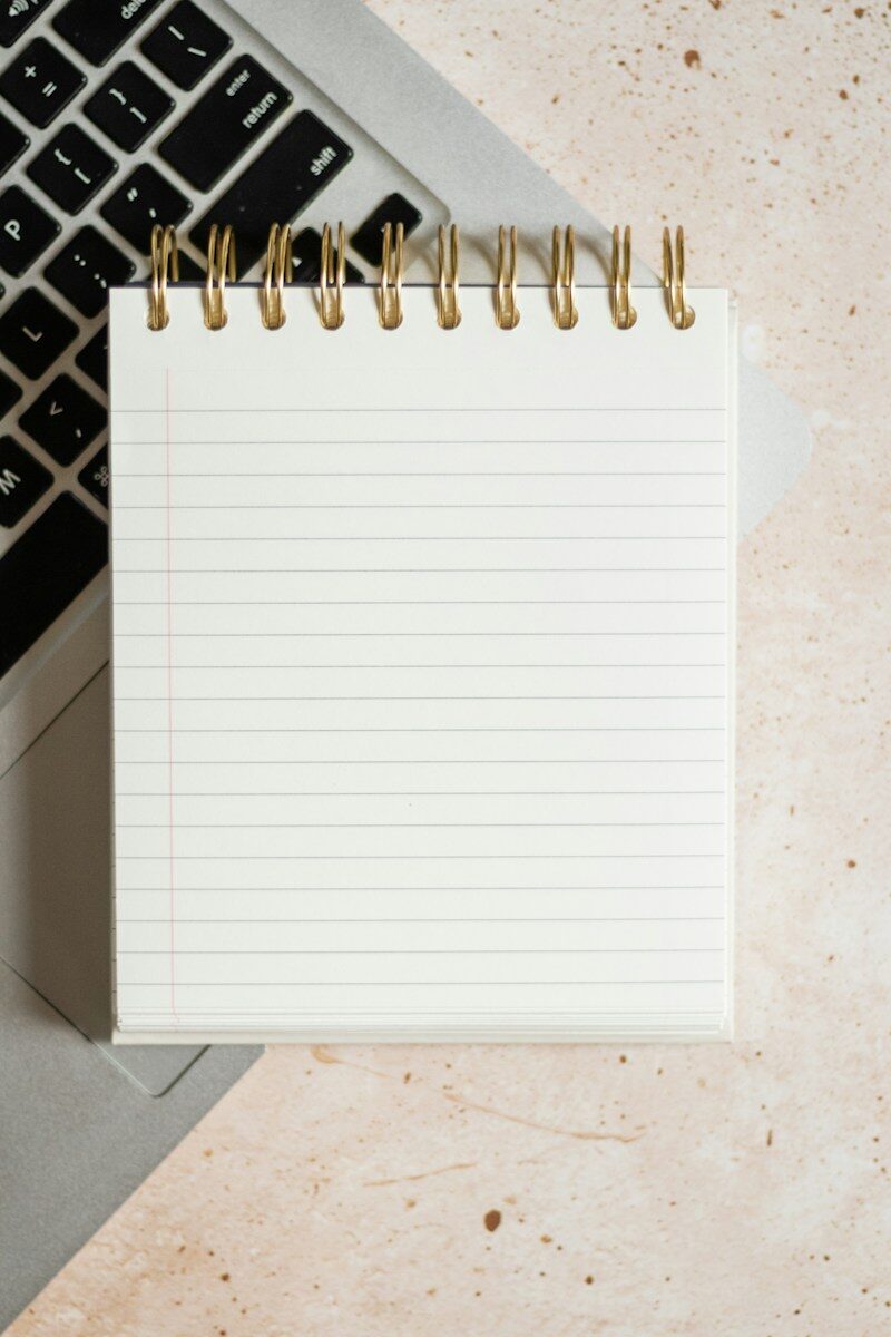 Bloc de notas sobre un portátil en una mesa de trabajo